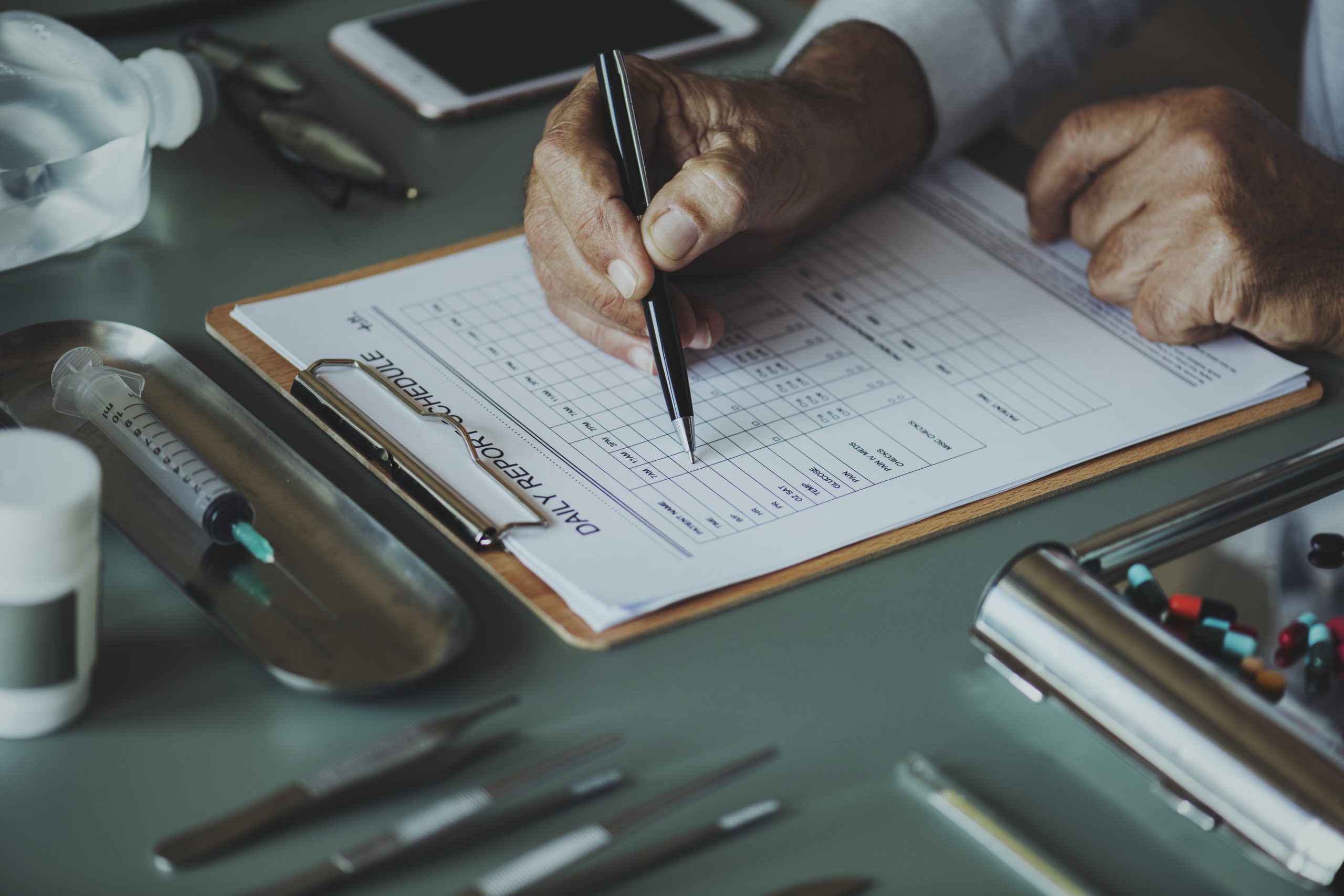Closeup of doctor checking patient daily report checklist