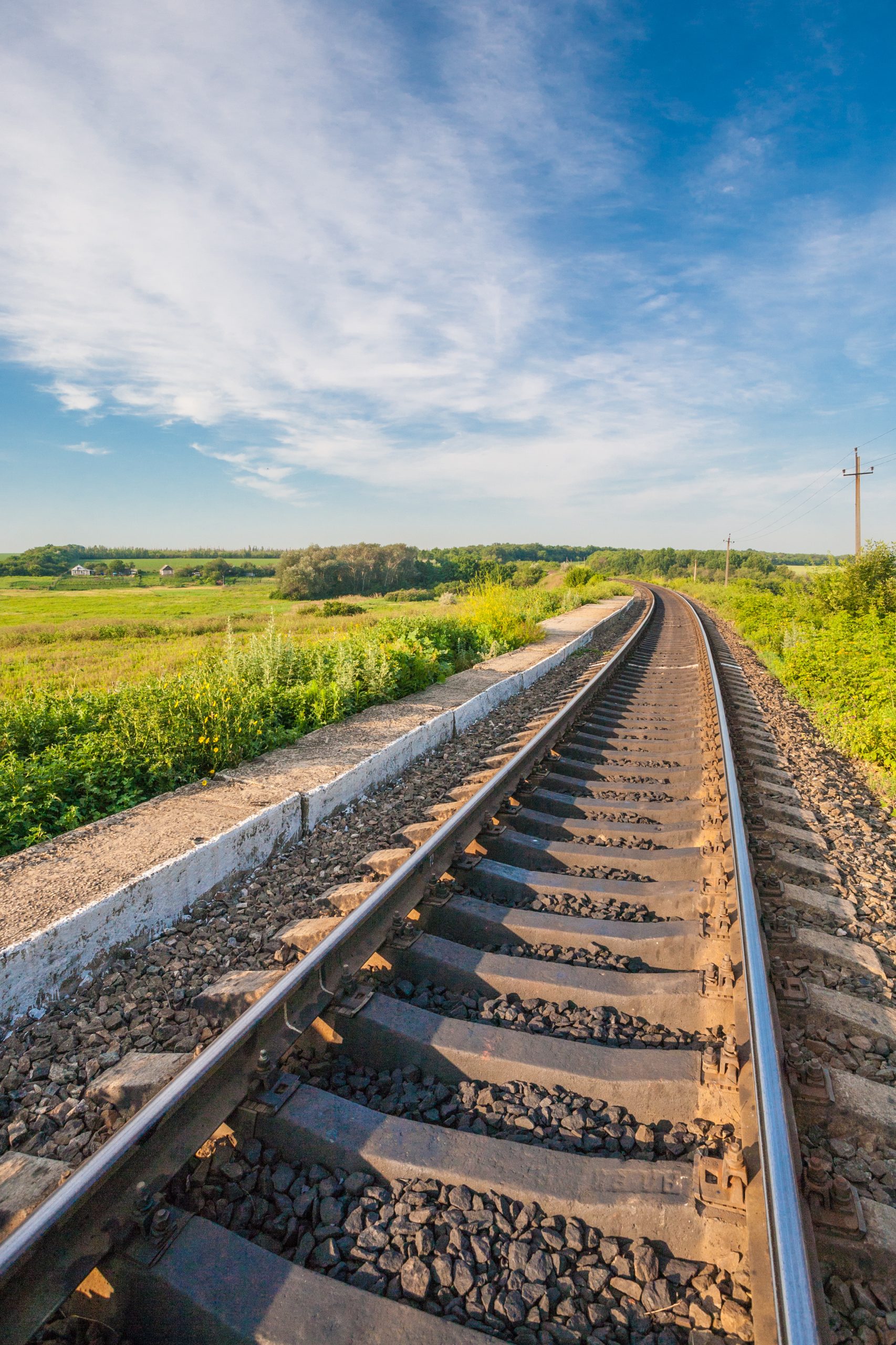 Railway station against beautiful sky at sunset. Industrial landscape with railroad, colorful cloudy blue sky.